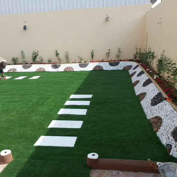 عشب صناعي مع ممرات حجرية في حديقة بالرياض